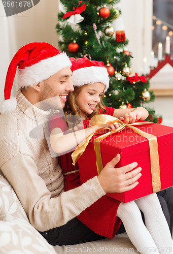 Image of smiling father and daughter opening gift box