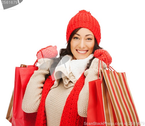 Image of smiling woman in warm clothers with shopping bags