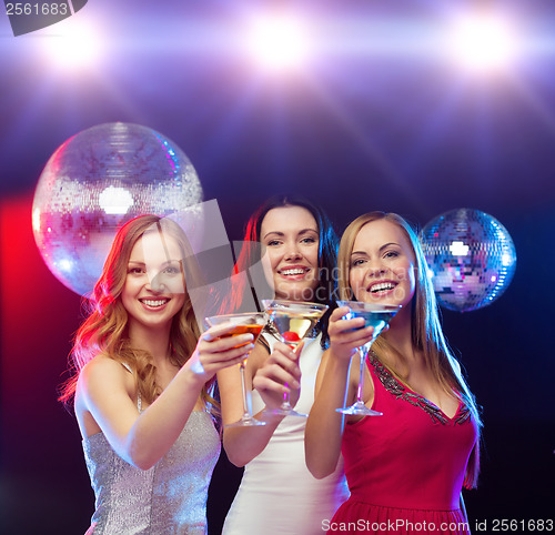 Image of three smiling women with cocktails and disco ball