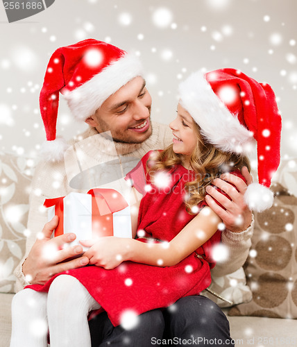 Image of smiling father and daughter holding gift box