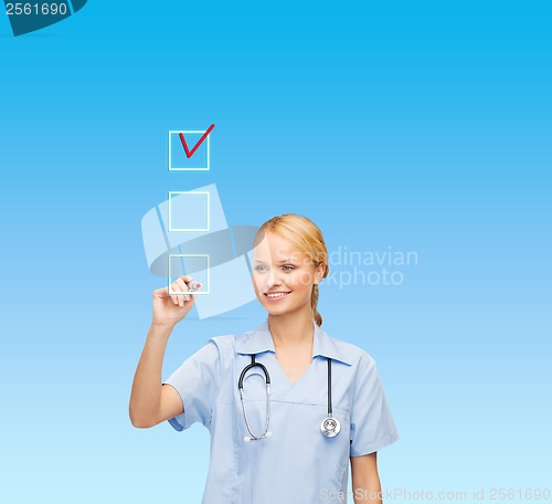 Image of doctor or nurse drawing checkmark into checkbox