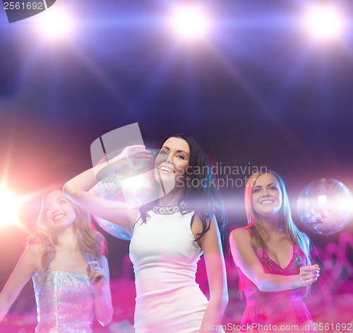 Image of three smiling women dancing in the club