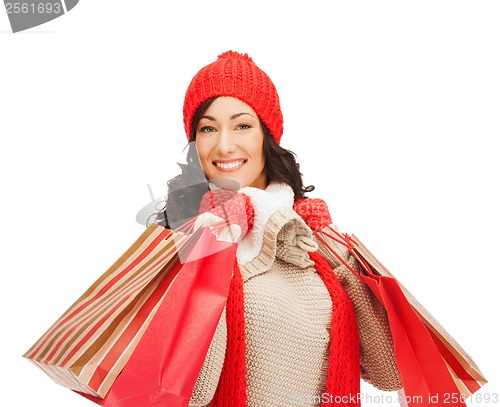 Image of smiling woman in warm clothers with shopping bags