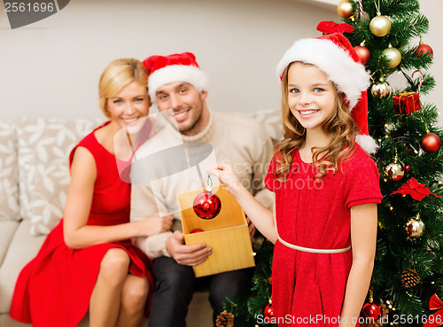 Image of smiling family decorating christmas tree