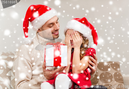 Image of smiling daughter waiting for a present from father