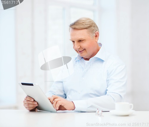 Image of old man with tablet pc computer at home