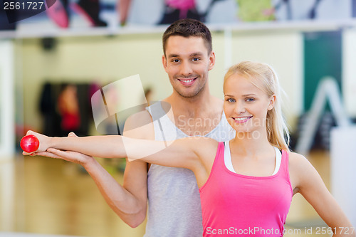 Image of male trainer with woman working out with dumbbell