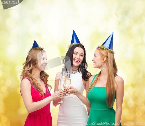 Image of three women wearing hats with champagne glasses