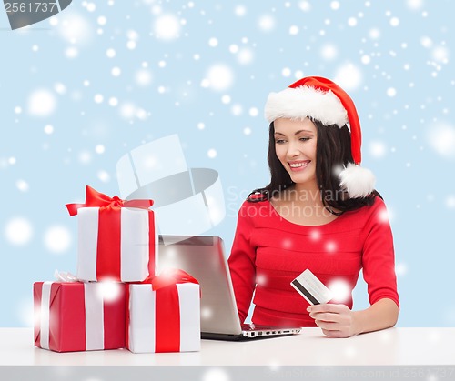 Image of woman with gifts, laptop computer and credit card