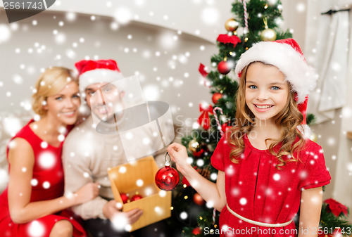 Image of smiling family decorating christmas tree