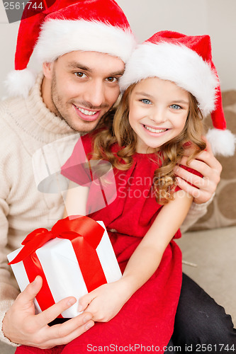 Image of smiling father and daughter holding gift box