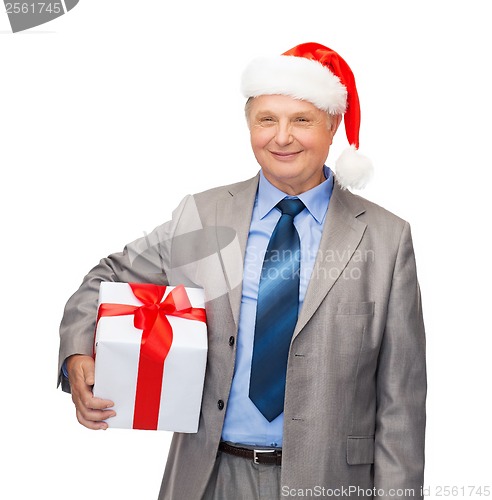 Image of smiling man in suit and santa helper hat with gift