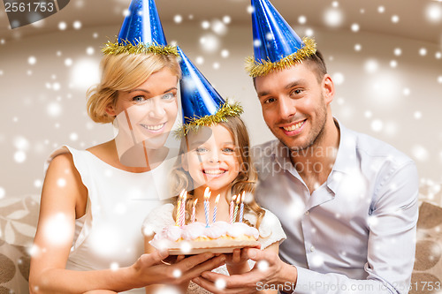 Image of smiling family in blue hats with cake