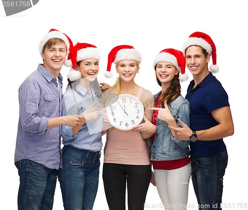 Image of group of smiling students with clock showing 12