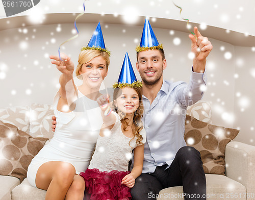 Image of happy family in blue hats throwing serpentine