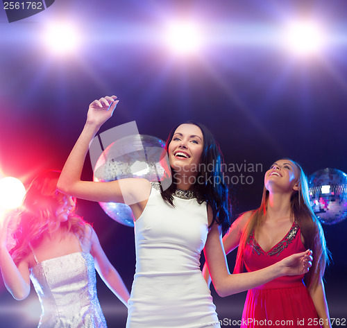 Image of three smiling women dancing in the club