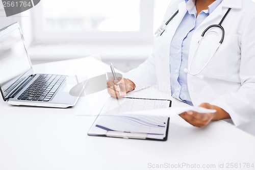 Image of female doctor writing prescription