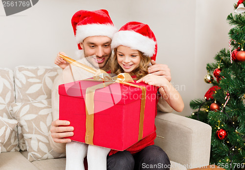 Image of smiling father and daughter opening gift box