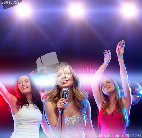 Image of three smiling women dancing and singing karaoke