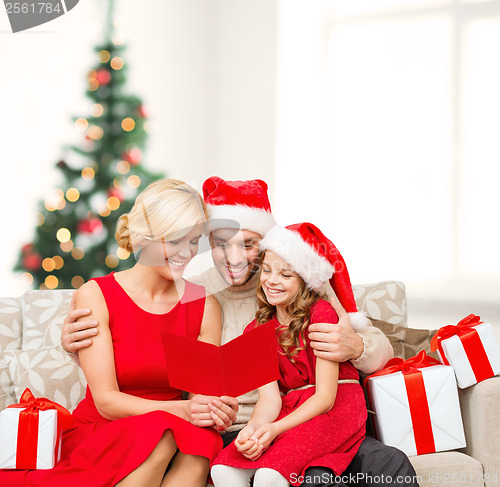 Image of smiling family reading postcard