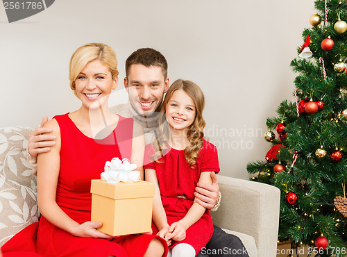 Image of smiling family holding gift box