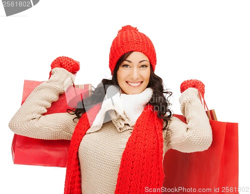 Image of smiling woman in warm clothers with shopping bags