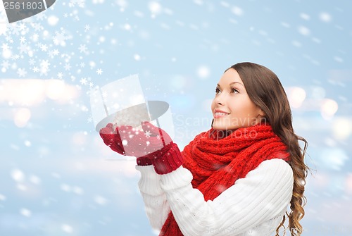 Image of woman in scarf and mittens with christmas ball