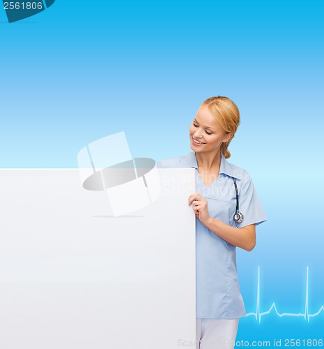 Image of smiling female doctor or nurse with blank board