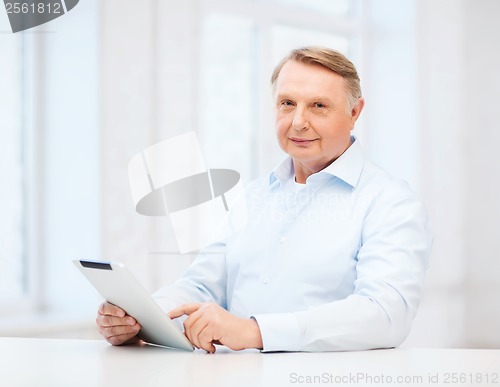 Image of old man with tablet computer at home