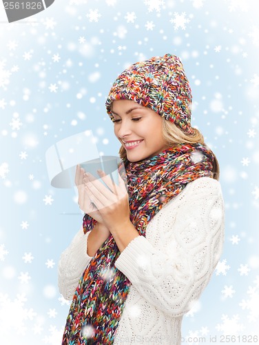 Image of woman in hat with red tea or coffee mug