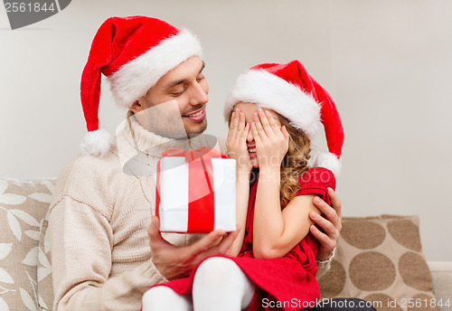 Image of smiling daughter waiting for a present from father