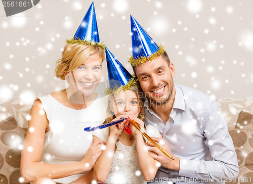 Image of smiling family in blue hats blowing favor horns