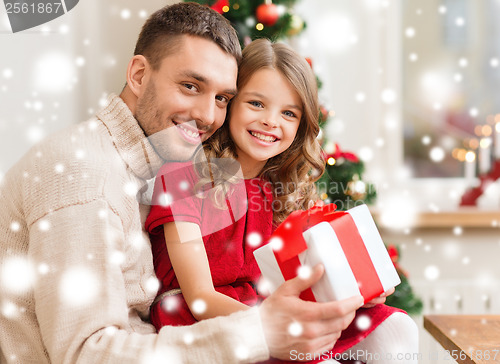 Image of smiling father and daughter holding gift box