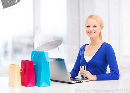 Image of woman with shopping bags, laptop and credit card