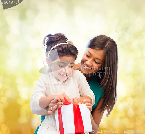 Image of happy mother and child girl with gift box