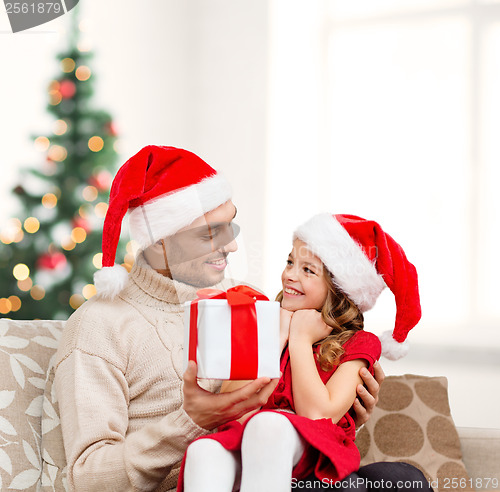 Image of smiling father giving daughter gift box