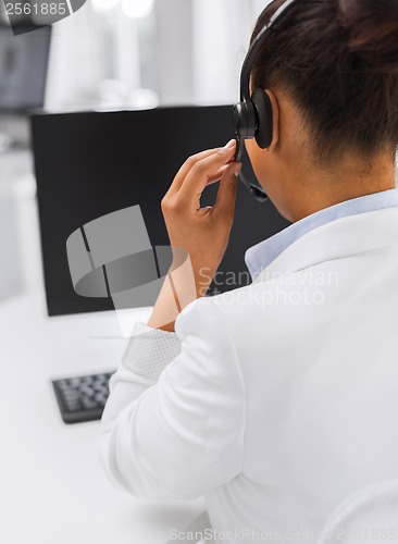 Image of friendly female helpline operator with headphones