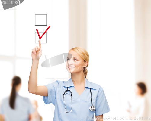 Image of doctor or nurse drawning checkmark into checkbox