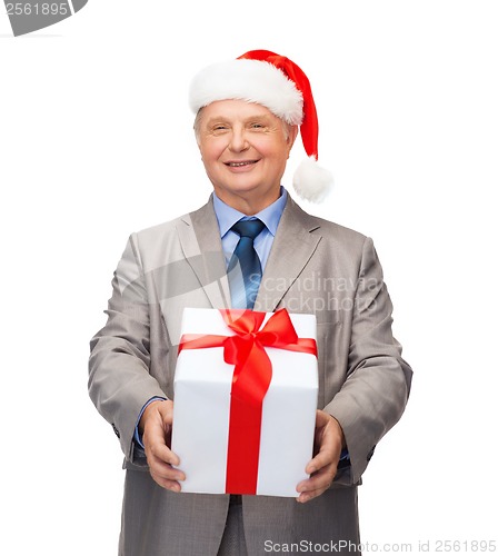 Image of smiling man in suit and santa helper hat with gift