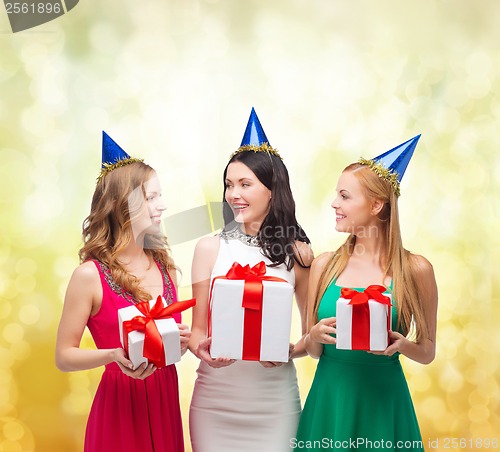 Image of three smiling women in blue hats with gift boxes