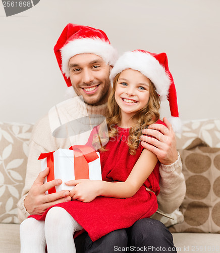 Image of smiling father and daughter holding gift box