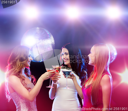 Image of three smiling women with cocktails and disco ball