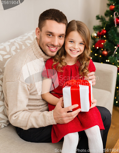 Image of smiling father and daughter holding gift box