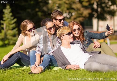 Image of teenagers taking photo outside with smartphone