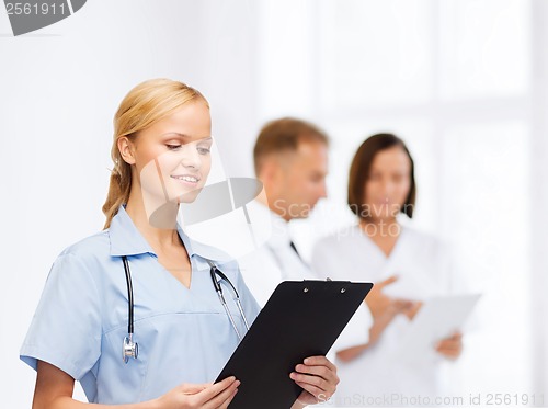 Image of smiling female doctor or nurse with clipboard