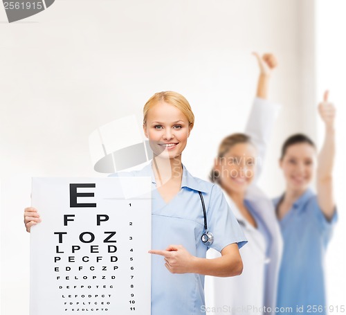 Image of smiling female doctor or nurse with eye chart