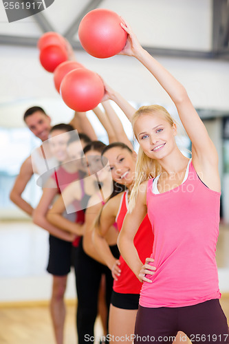 Image of group of smiling people working out with ball