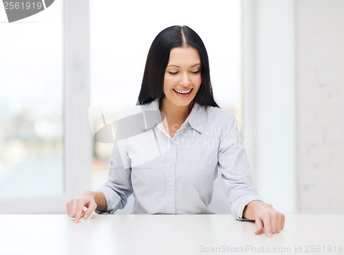 Image of smiling woman pointing to something imaginary