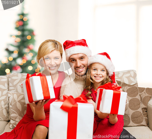 Image of smiling family giving many gift boxes