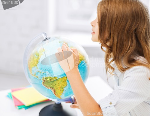 Image of curious student girl with globe at school